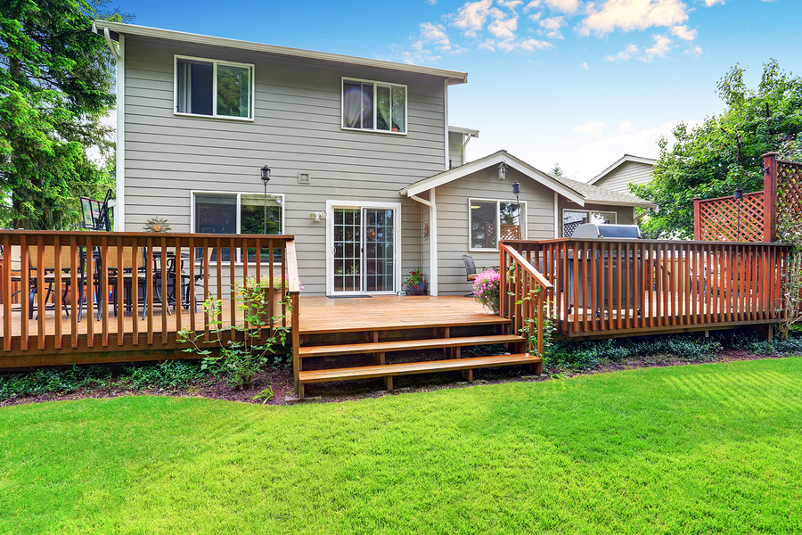 back yard house exterior with spacious wooden deck with patio area and attached pergola