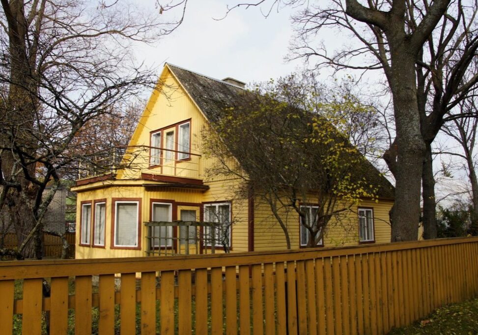 a yellow house with fence